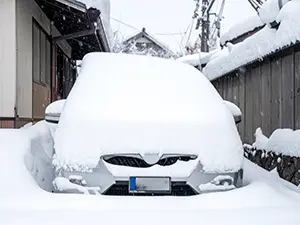 大雪により車体全体が分厚い雪ですっぽりと覆われてしまったシルバーの車